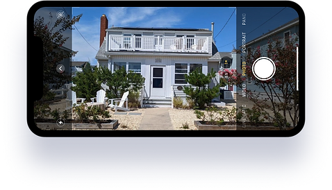A phone taking a photo of a house