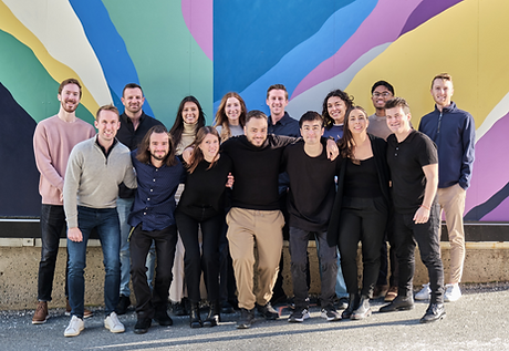 Neuron team photo in front of a mural